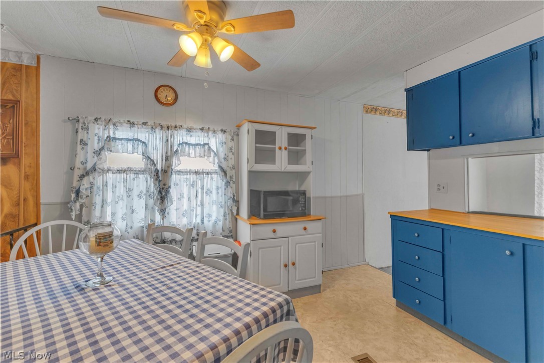 6610 Lear Nagle Road, Unit 154 North Ridgeville, OH 44039 - Photo 14 of 26 Bedroom with a ceiling fan, a textured ceiling, and wooden walls