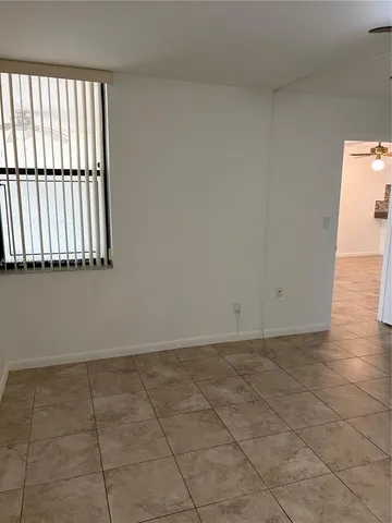 a view of a room with wooden floor and a window