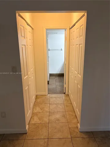 a view of a hallway with wooden shelves