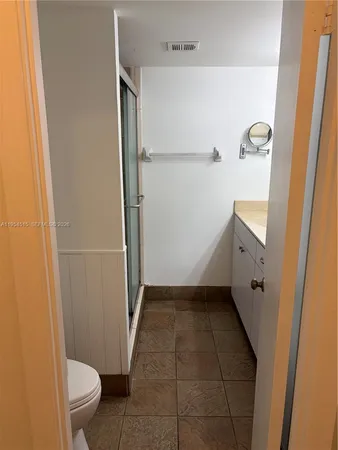 a bathroom with a granite countertop sink toilet and shower