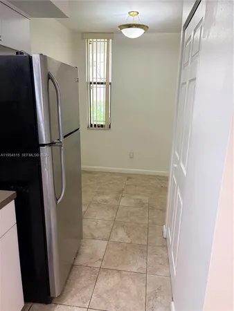 a view of a refrigerator in kitchen and entryway in a room