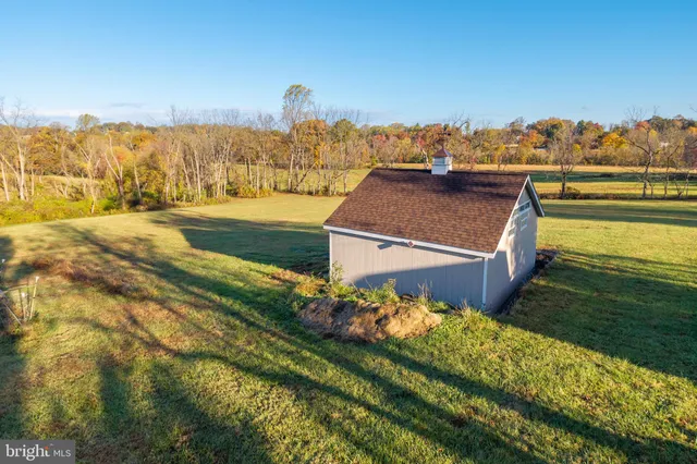 a front view of house with yard and trees in the background