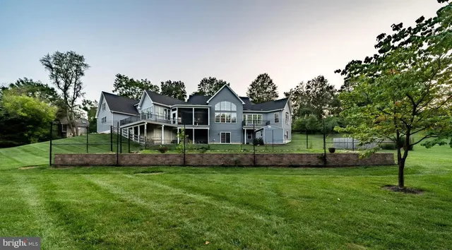 a view of a house with a big yard plants and large trees