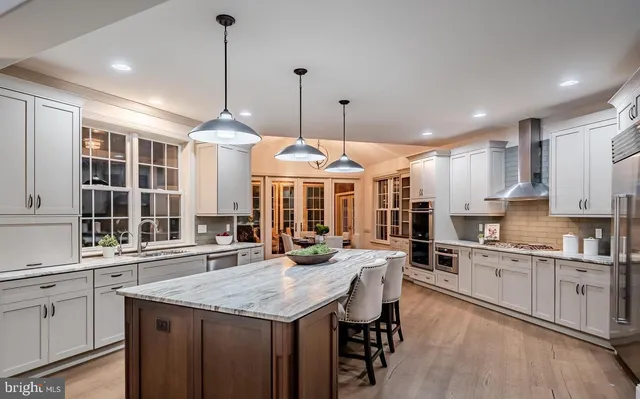 a kitchen with center island table and chairs in it