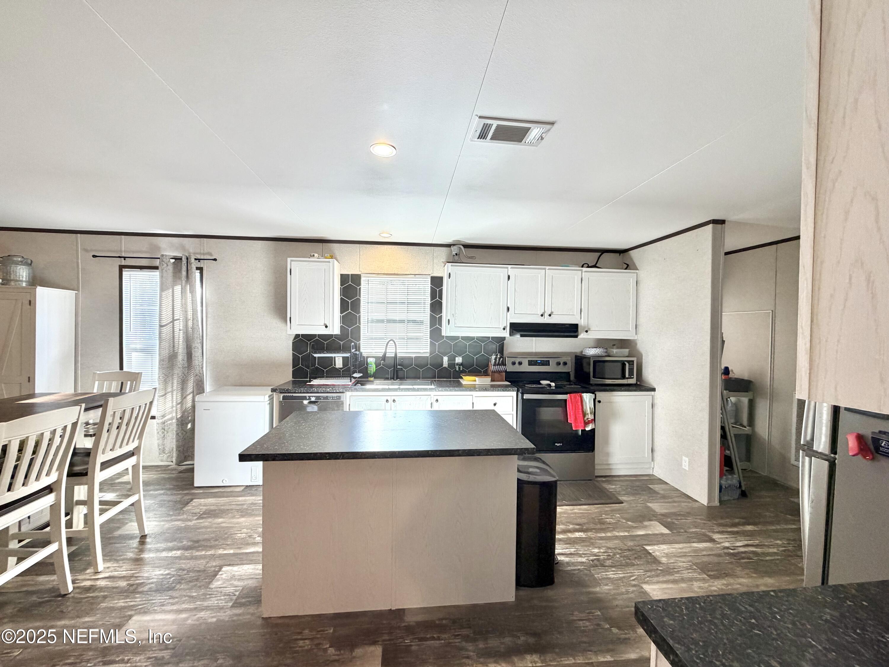 5915 Oak Leaf Road Keystone Heights, FL 32656 - Photo 15 of 44 a kitchen with stainless steel appliances granite countertop a stove and a refrigerator