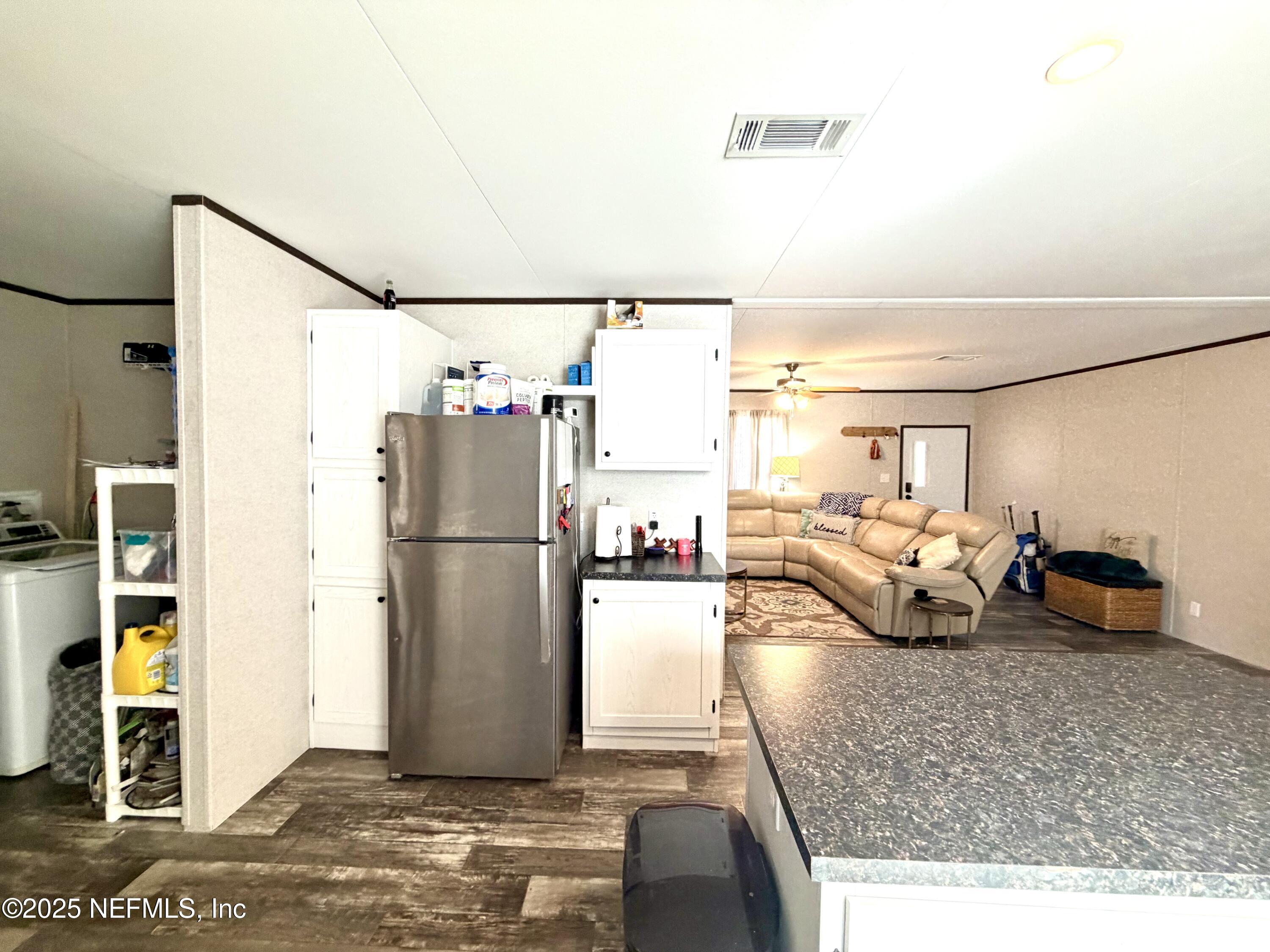 5915 Oak Leaf Road Keystone Heights, FL 32656 - Photo 17 of 44 a living room with furniture and a refrigerator
