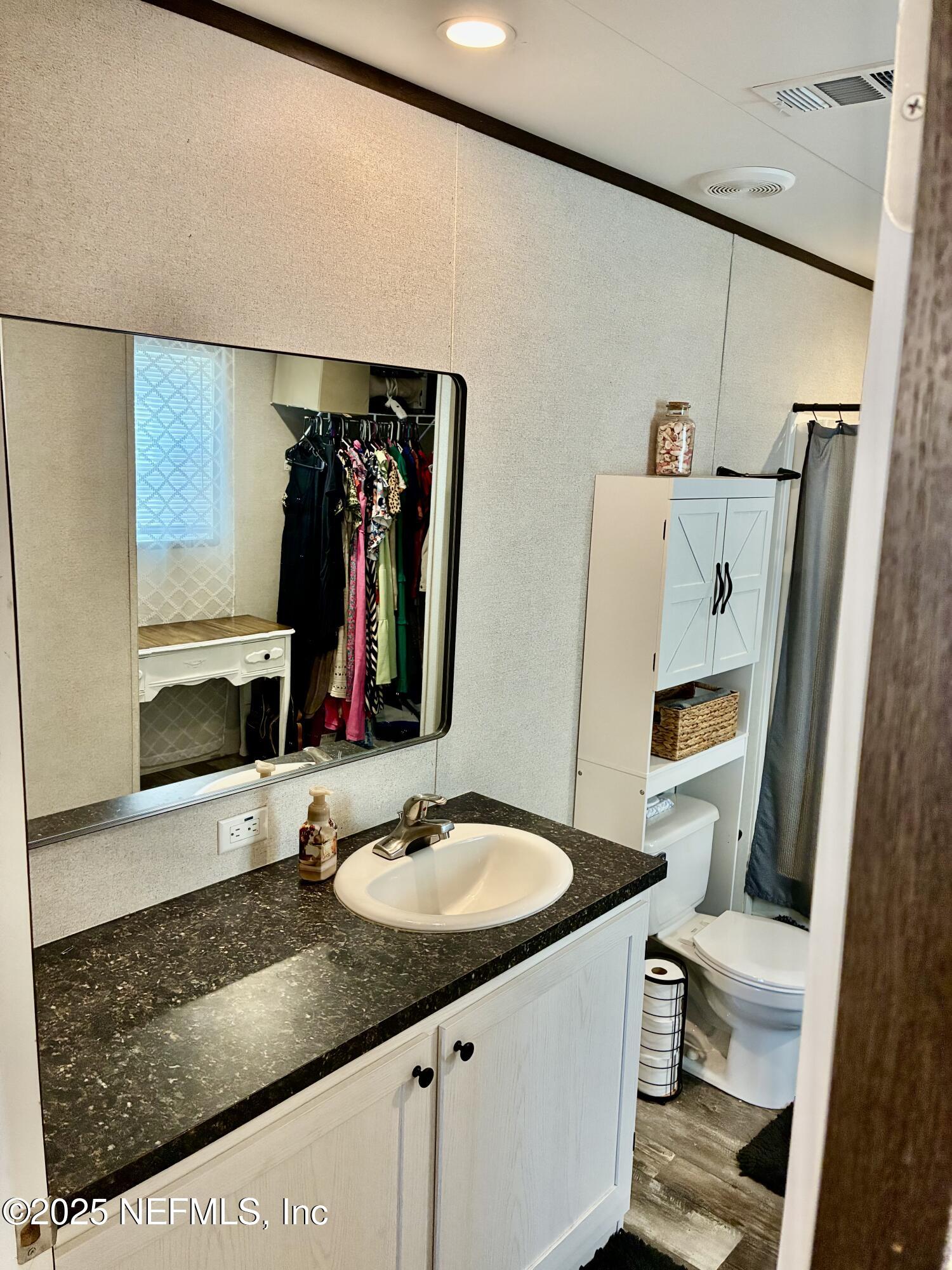 5915 Oak Leaf Road Keystone Heights, FL 32656 - Photo 22 of 44 a bathroom with a granite countertop sink and a mirror