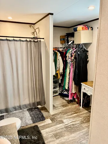 a view of walk in closet with clothes and shoes