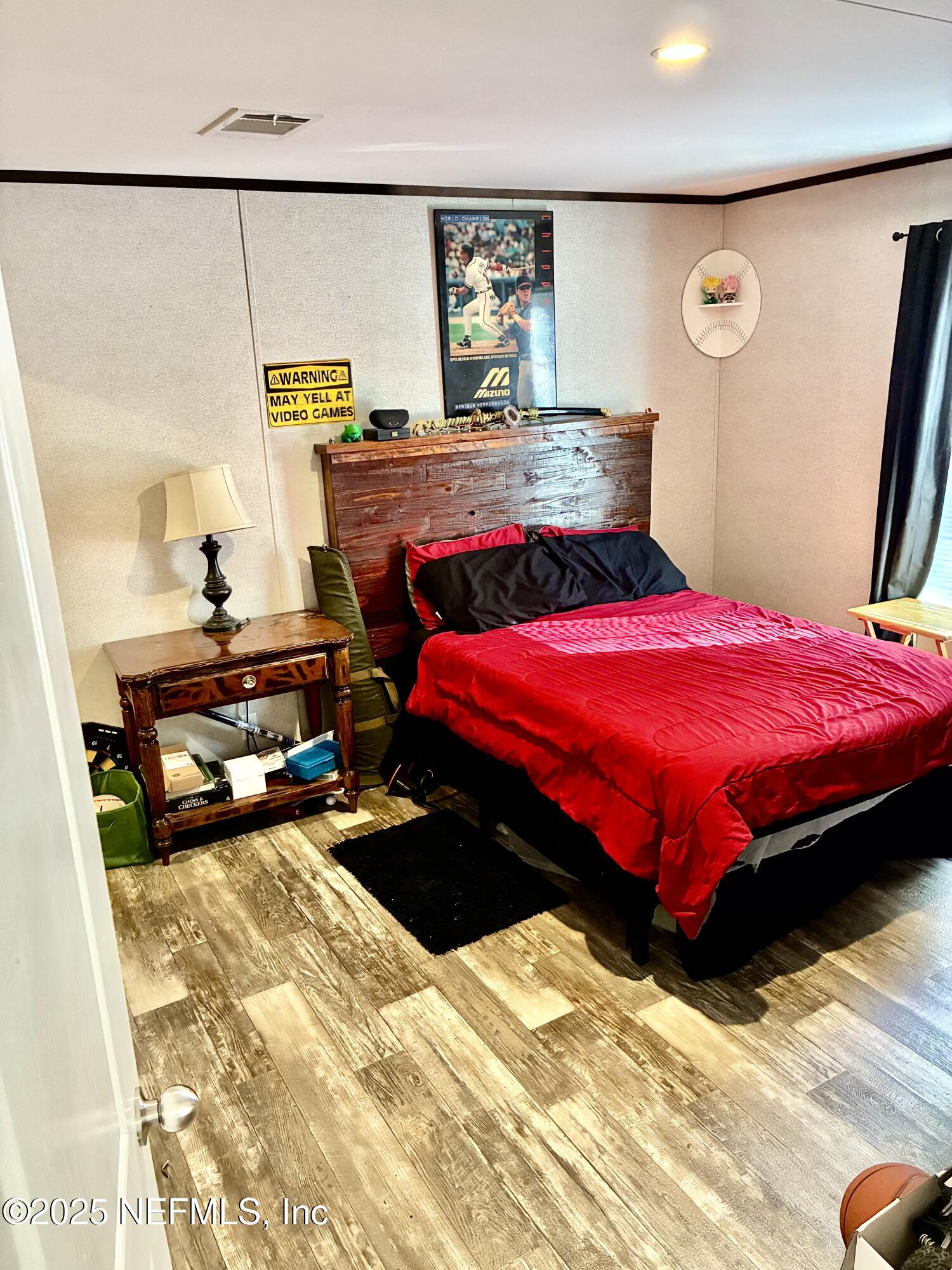 5915 Oak Leaf Road Keystone Heights, FL 32656 - Photo 30 of 44 a bedroom with a bed and wooden floor