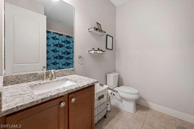 6564 Bay Ridge Way Fort Myers, FL 33908 - Photo 10 of 17 a bathroom with a granite countertop sink a toilet and a mirror