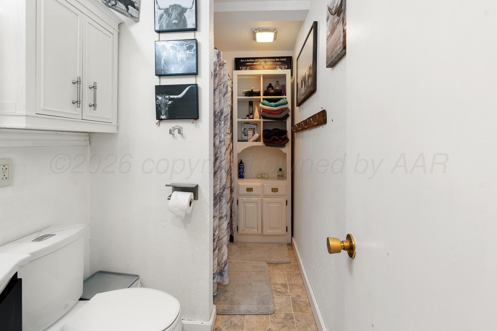 4603 Parker Street Amarillo, TX 79110 - Photo 16 of 20 a bathroom with a toilet and a shower