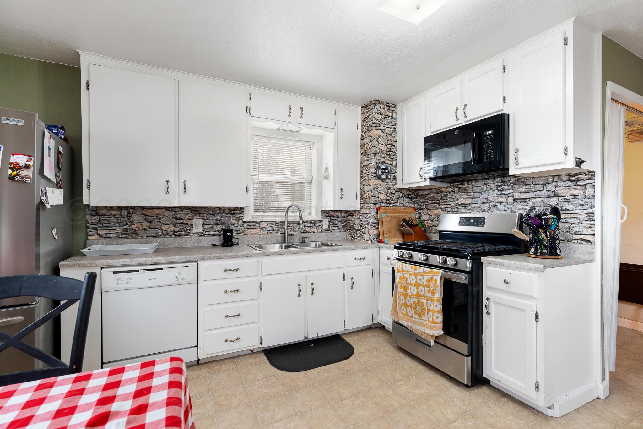 4603 Parker Street Amarillo, TX 79110 - Photo 9 of 20 a kitchen with stainless steel appliances granite countertop a stove and a sink