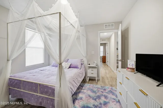 a living room with a bed furniture and a flat screen tv