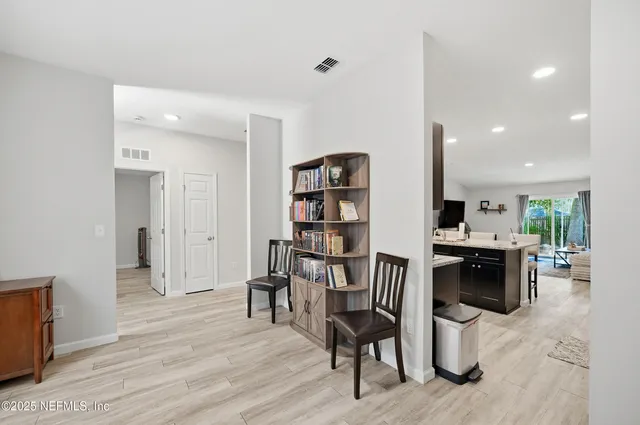 a kitchen with stainless steel appliances a table chairs refrigerator and cabinets