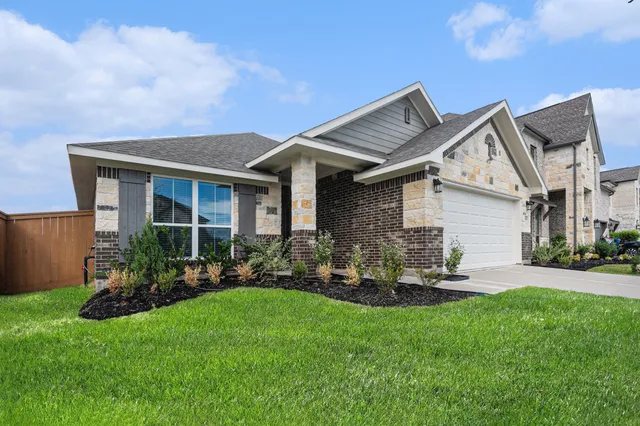 a front view of a house with a garden and plants