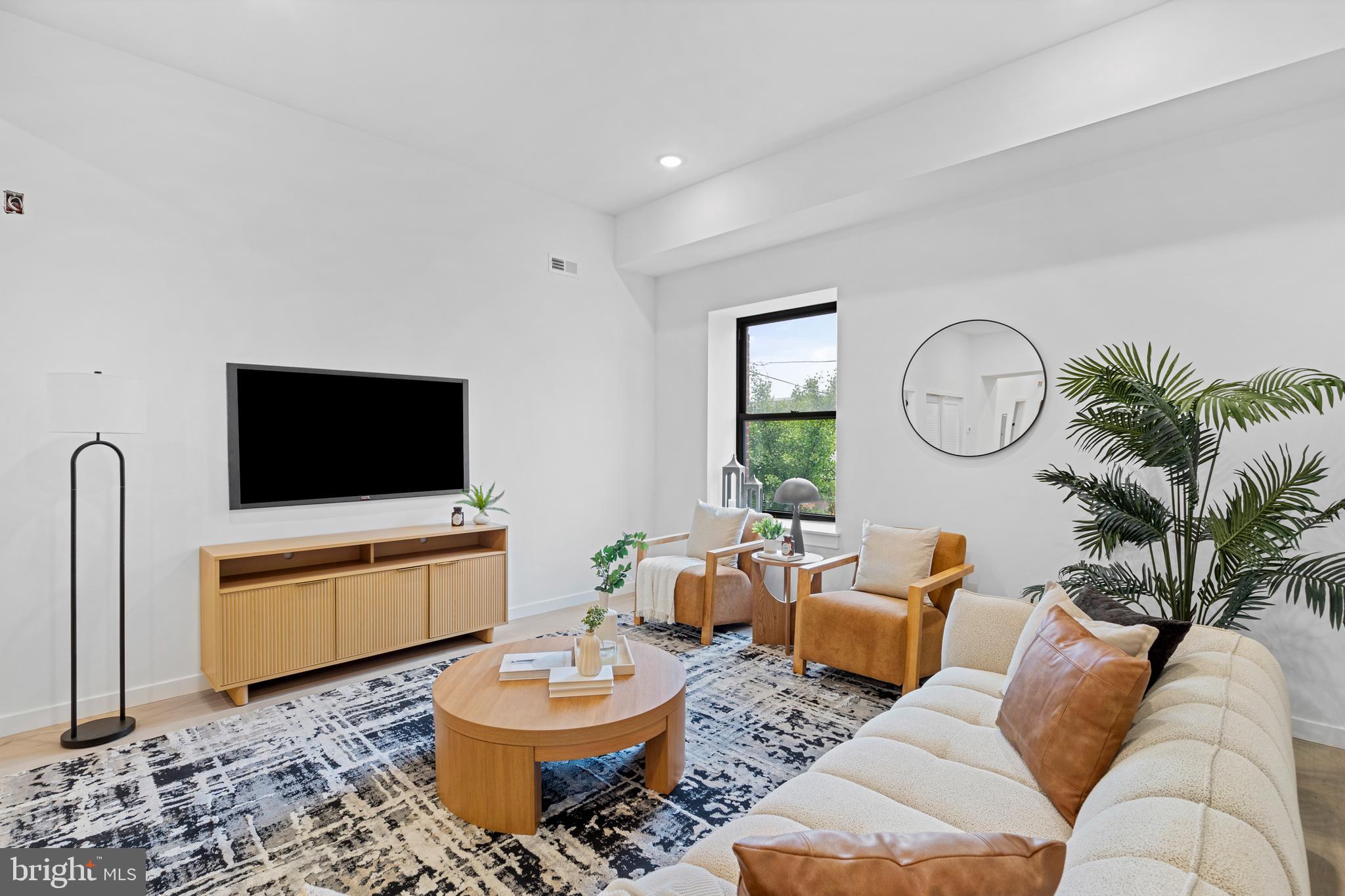 3211 Cedar Street, Unit 208 Philadelphia, PA 19134 - Photo 6 of 18 a living room with furniture a rug and a flat screen tv