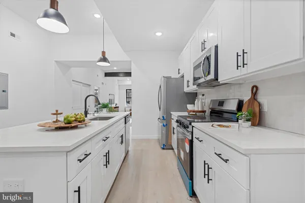 a kitchen with stainless steel appliances a sink stove and refrigerator