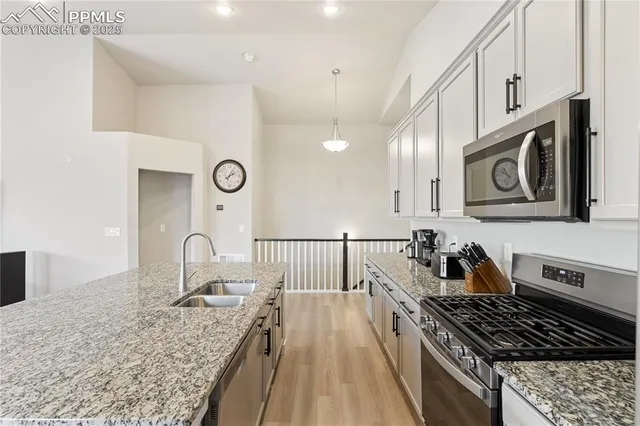 a kitchen with kitchen island granite countertop a stove and a sink