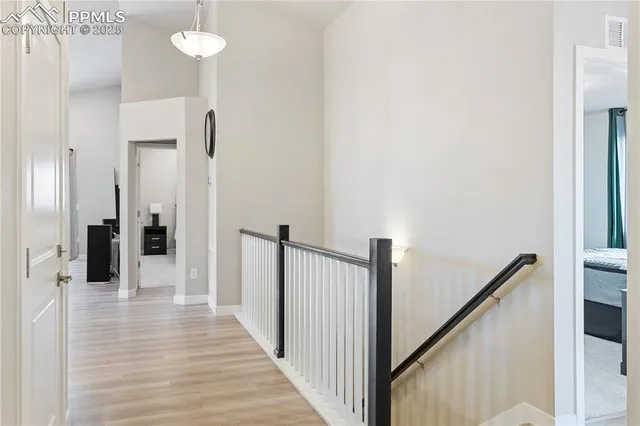 a view of a hallway with wooden floor and staircase