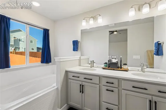 a bathroom with a sink double vanity granite tub shower and a mirror