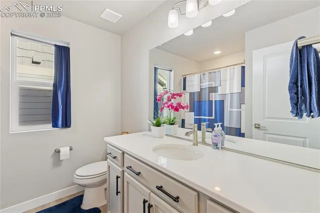a bathroom with a sink vanity granite and toilet