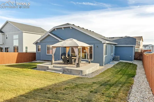 a view of a house with backyard and sitting area