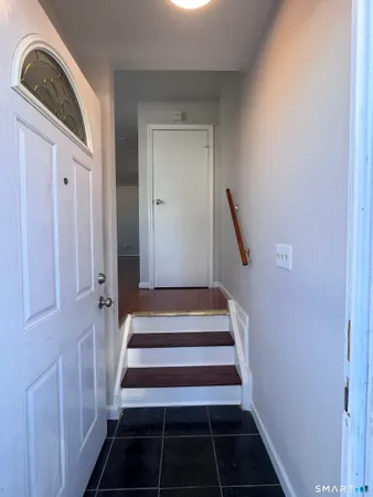 a view of a hallway with wooden cabinets and staircase