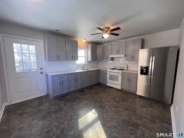 a kitchen with stainless steel appliances a refrigerator sink and cabinets