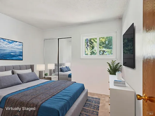 a bedroom with a large bed and a potted plant