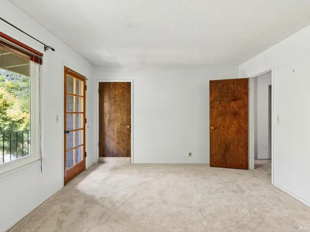 an empty room with windows and closet