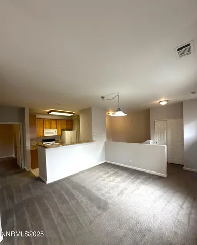 a view of a kitchen with furniture and an empty room