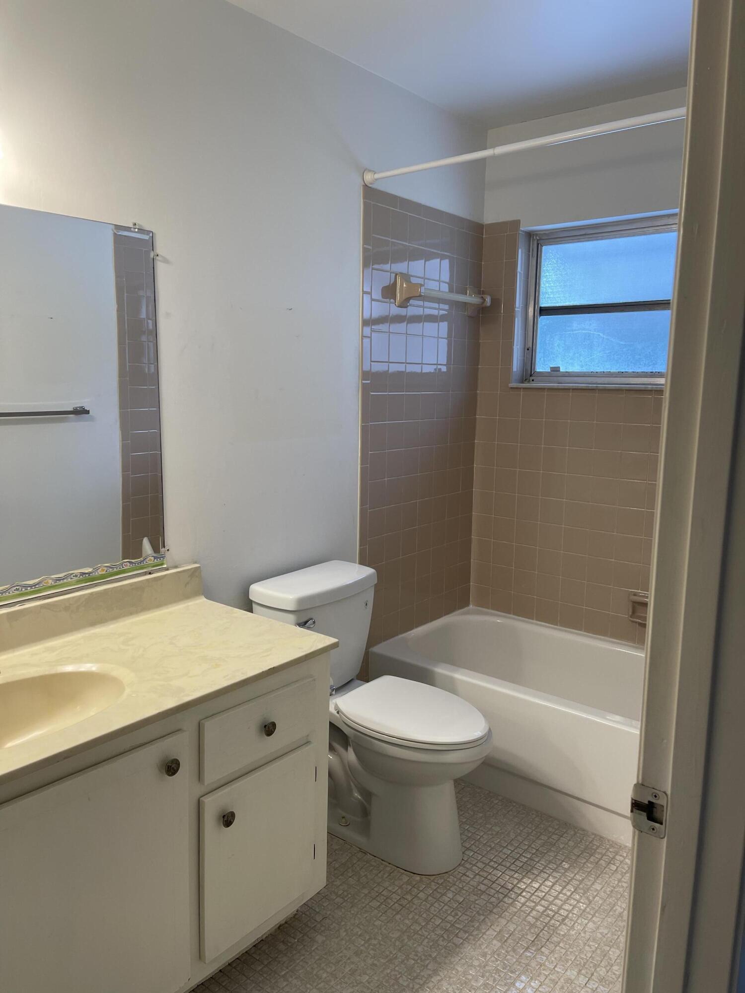 4530 Northwest 2nd Street, Unit D Delray Beach, FL 33445 - Photo 21 of 31 a bathroom with a granite countertop toilet a sink and bathtub