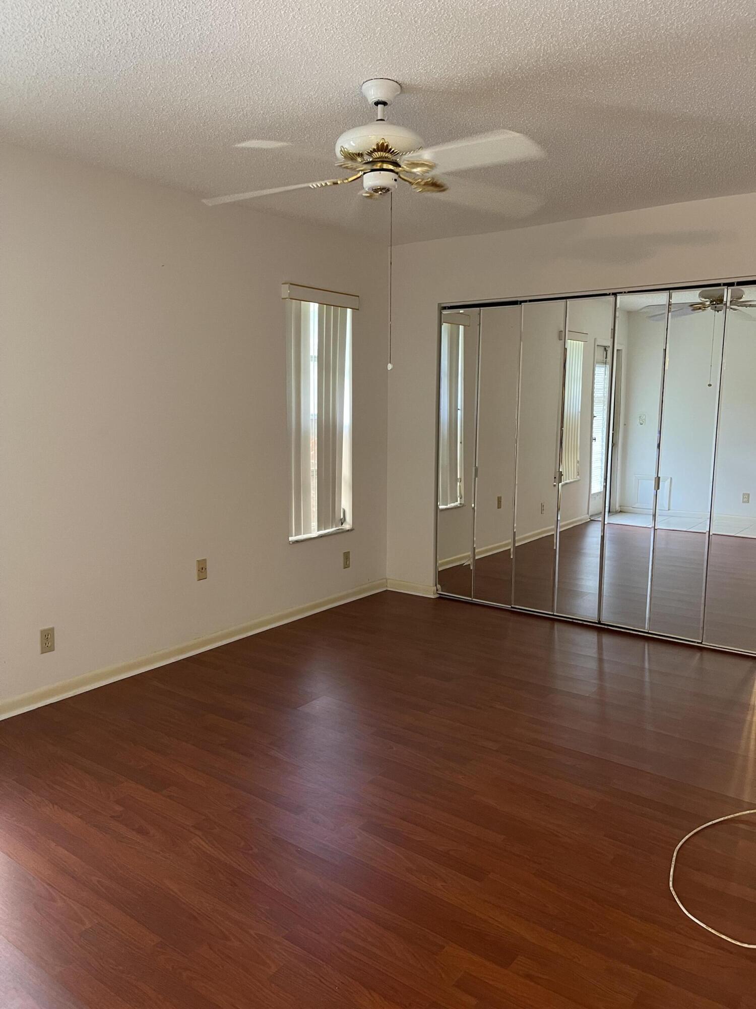 4530 Northwest 2nd Street, Unit D Delray Beach, FL 33445 - Photo 22 of 31 an empty room with wooden floor fan and windows