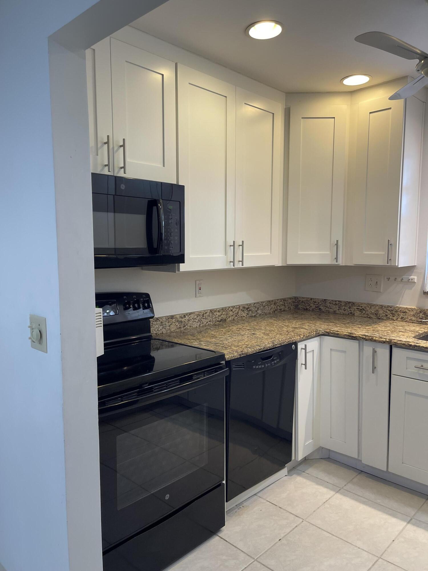4530 Northwest 2nd Street, Unit D Delray Beach, FL 33445 - Photo 6 of 31 a kitchen with stainless steel appliances granite countertop a stove and a microwave