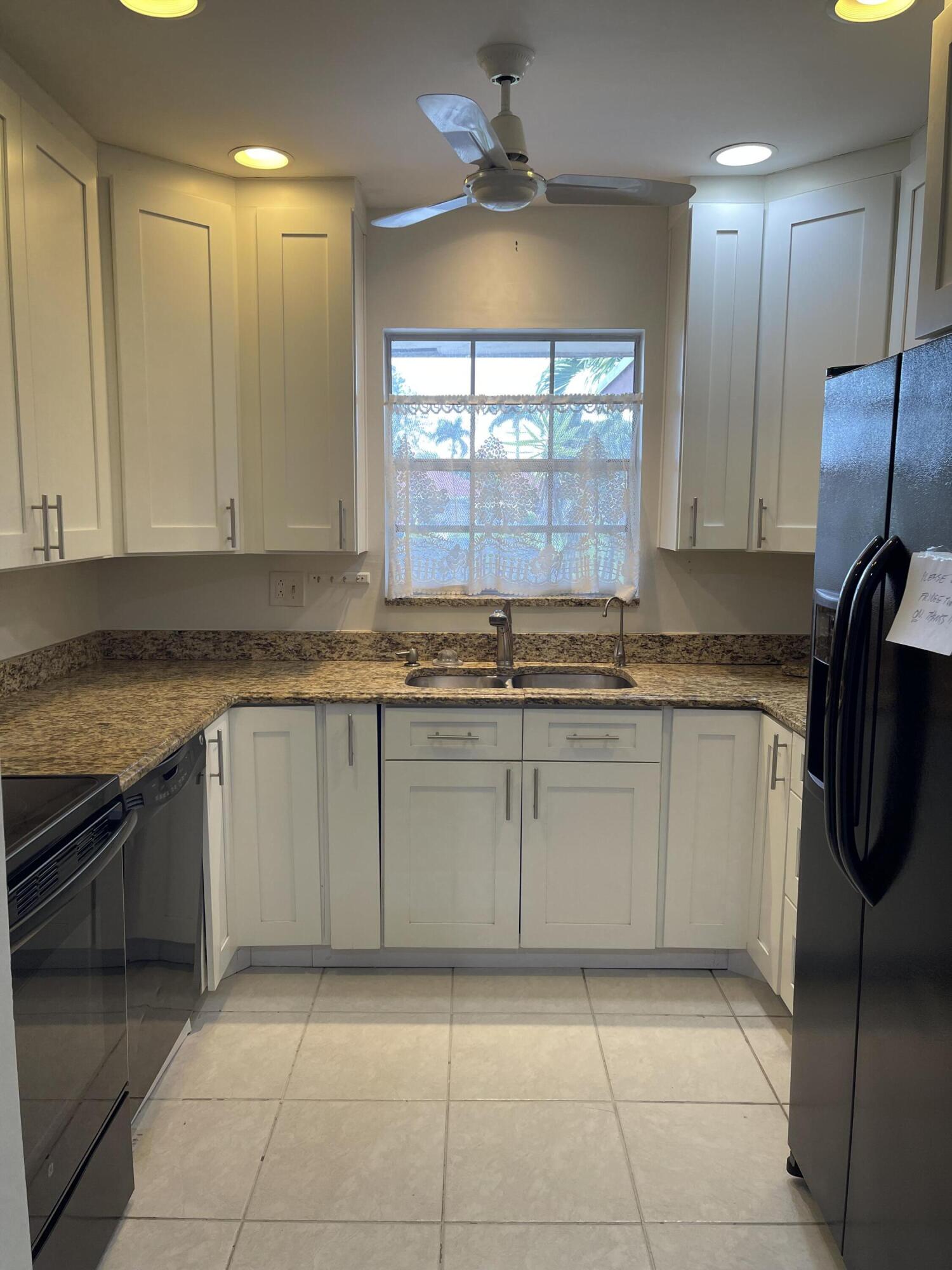 4530 Northwest 2nd Street, Unit D Delray Beach, FL 33445 - Photo 7 of 31 a kitchen with a refrigerator a sink and a stove
