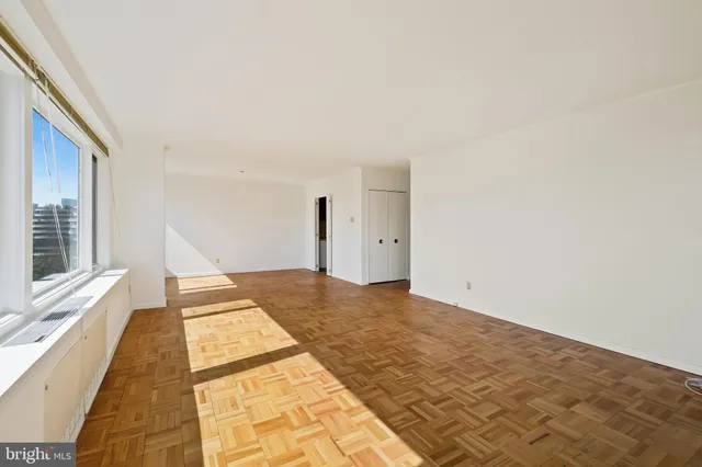 a view of a bedroom with a bed and wooden floor