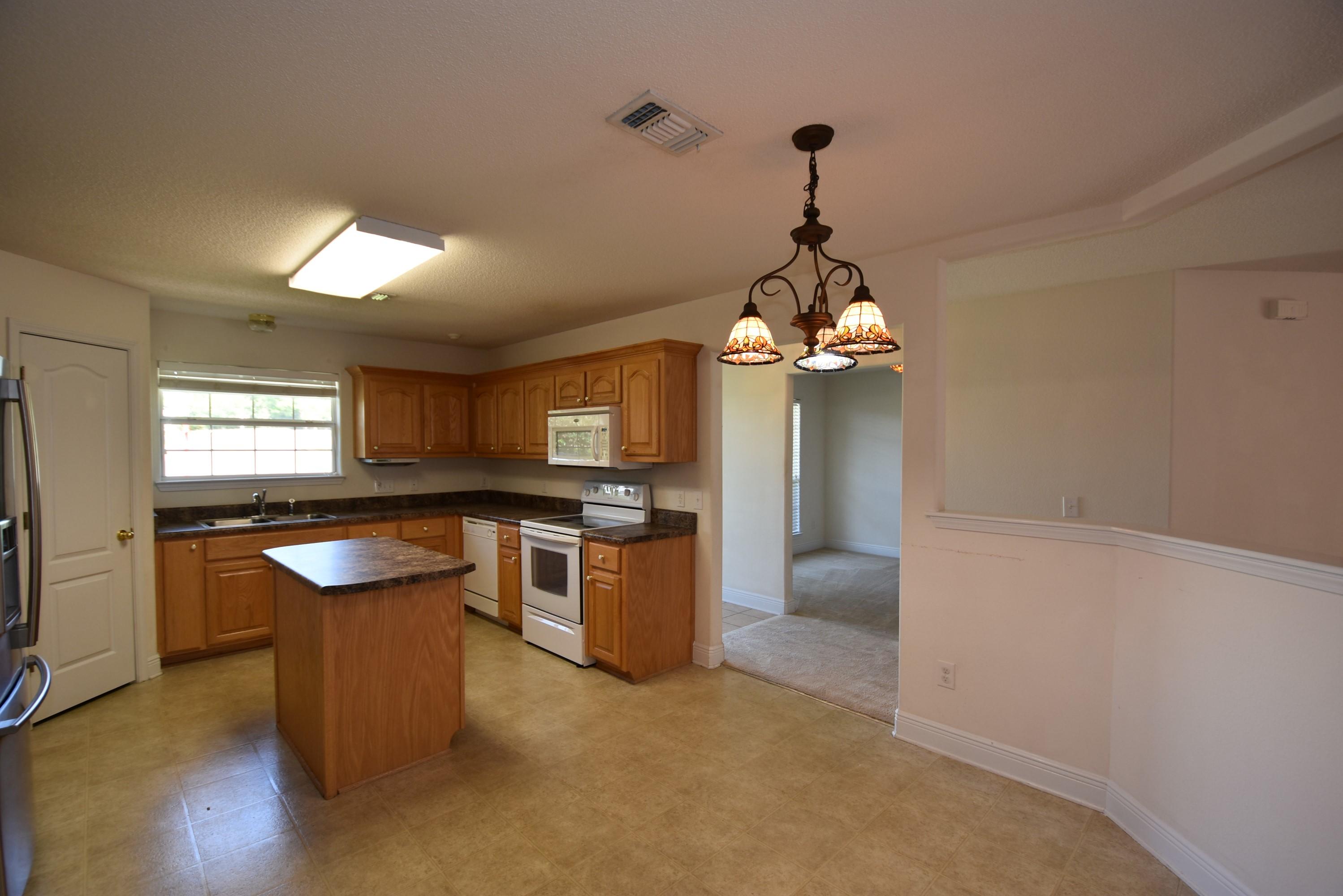 404 Swift Fox Run Crestview, FL 32536 - Photo 11 of 37 a kitchen with stove and refrigerator