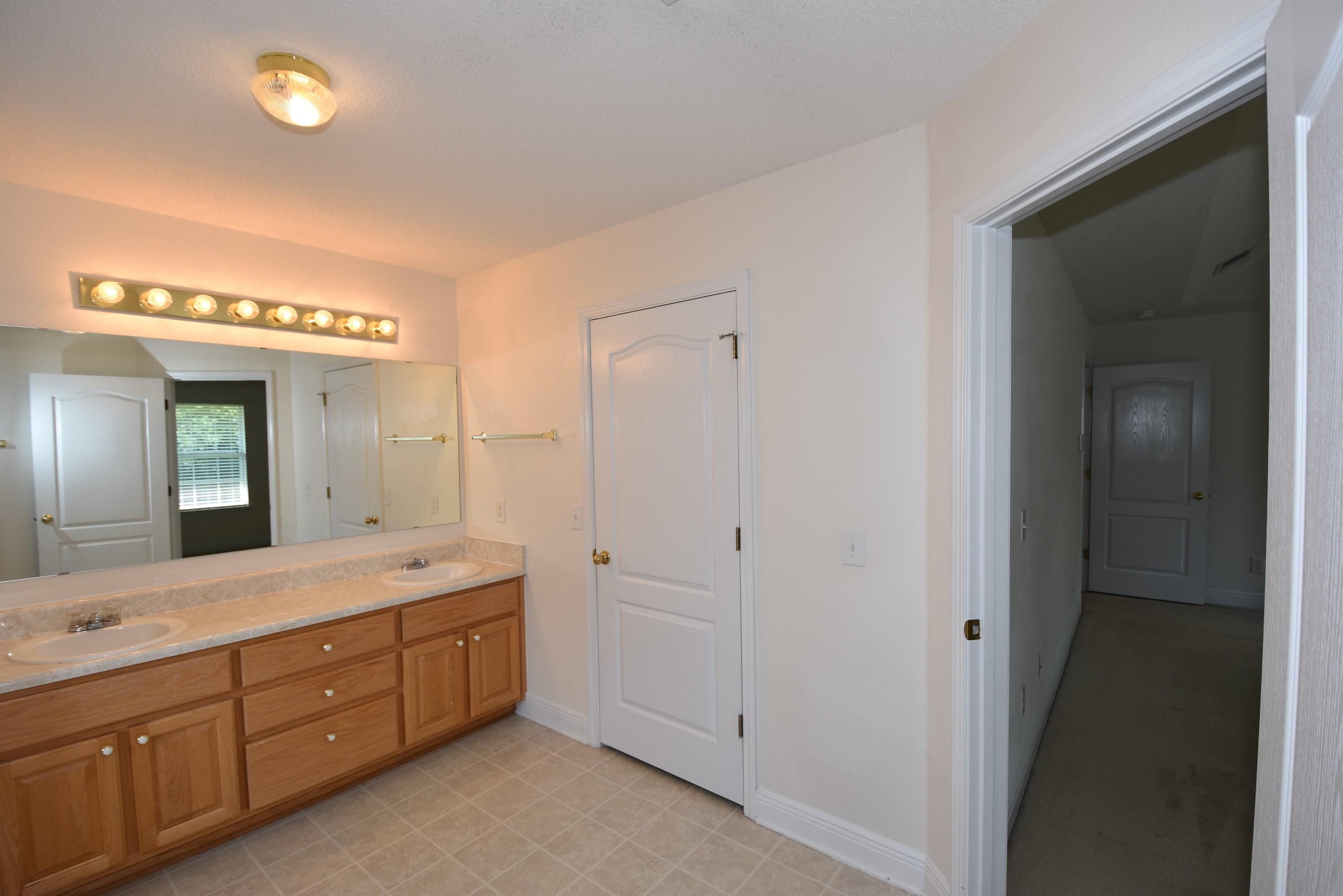 404 Swift Fox Run Crestview, FL 32536 - Photo 22 of 37 a spacious bathroom with a double vanity sink and a mirror