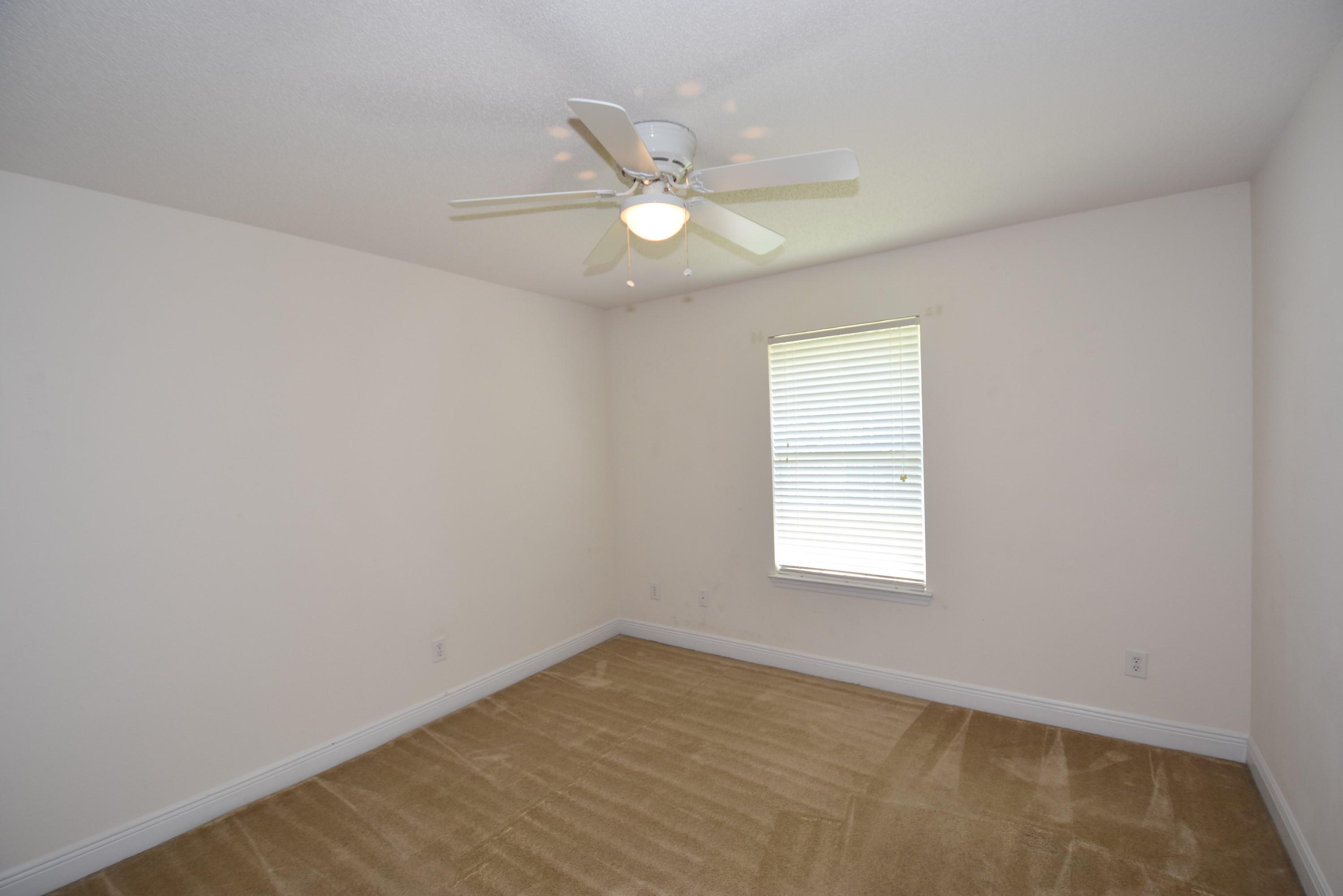 404 Swift Fox Run Crestview, FL 32536 - Photo 26 of 37 an empty room with a window and a fan