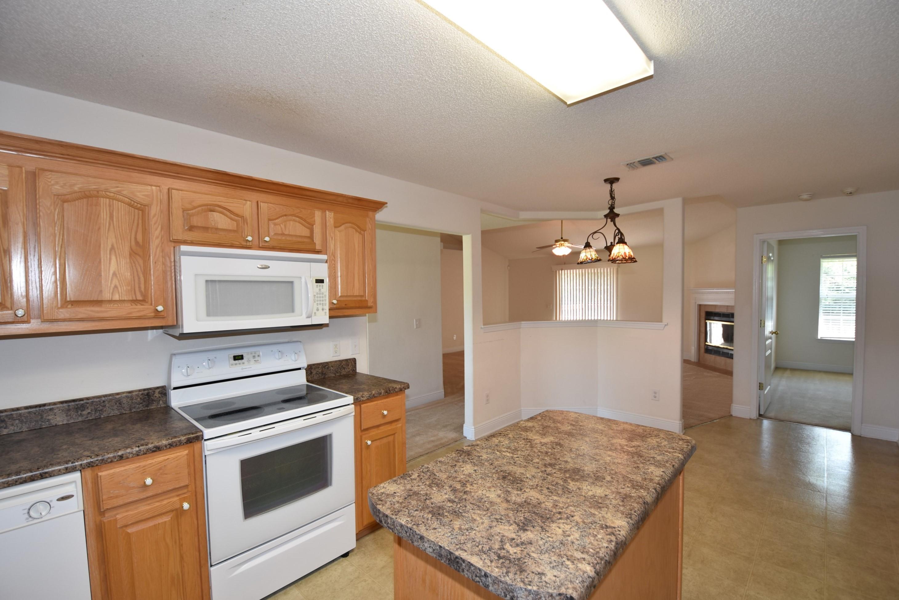 404 Swift Fox Run Crestview, FL 32536 - Photo 8 of 37 a kitchen with stainless steel appliances granite countertop a stove a sink and a microwave