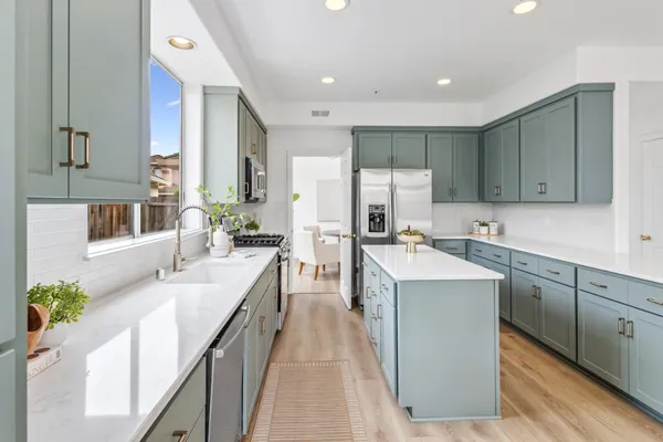 a large kitchen with stainless steel appliances kitchen island granite countertop a sink and cabinets
