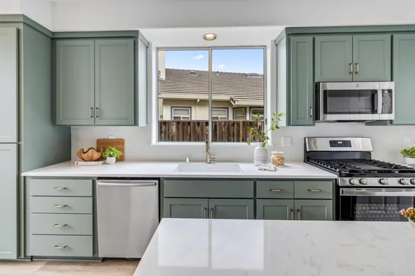 a kitchen with stainless steel appliances granite countertop a stove a sink and a microwave