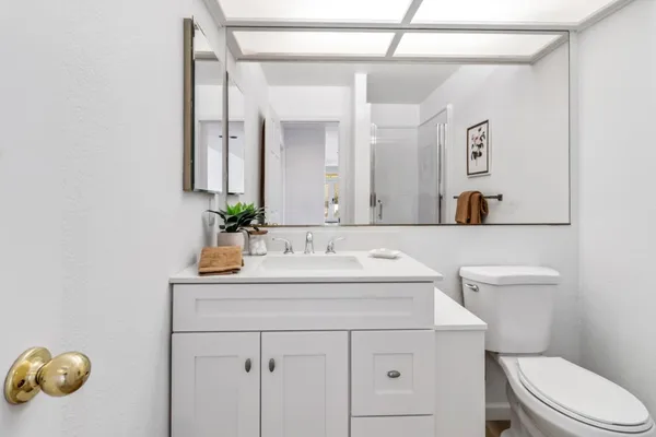 a bathroom with a sink vanity mirror and toilet