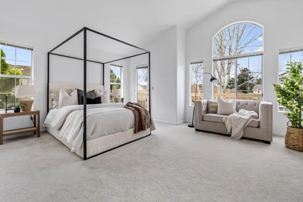 a bedroom with a bed couch and a window
