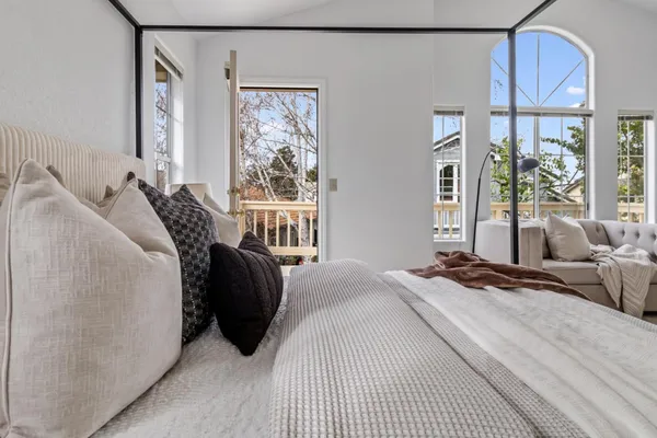 a bedroom with a bed and a large window