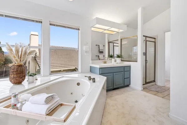 a spacious bathroom with a tub sink and mirror