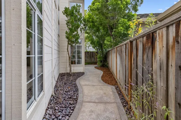 a view of a pathway of a house with wooden fence
