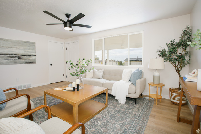 621 Timpie Road Tooele, UT 84074 - Photo 3 of 16 Spacious living area featuring light wood-finish flooring, a contemporary ceiling fan, and large windows providing ample natural light