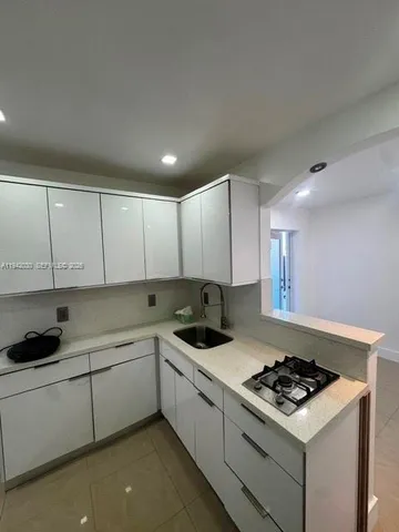 a kitchen that has a sink and a stove top oven