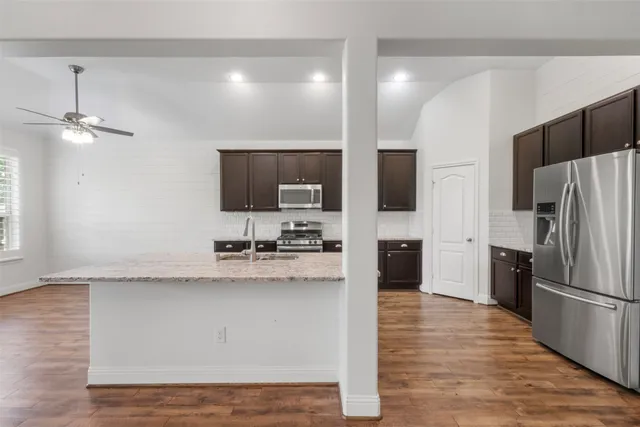 a kitchen with stainless steel appliances a refrigerator sink and microwave
